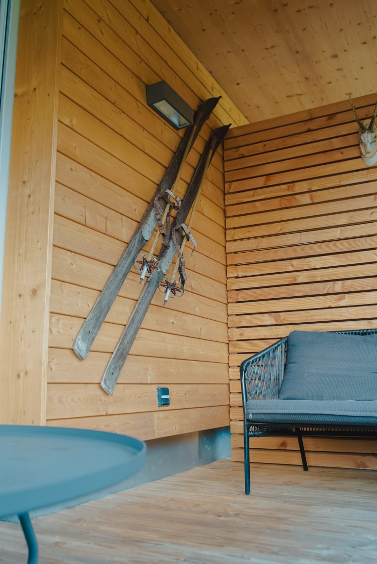 Antike Ski die an einer Holzwand hängen.